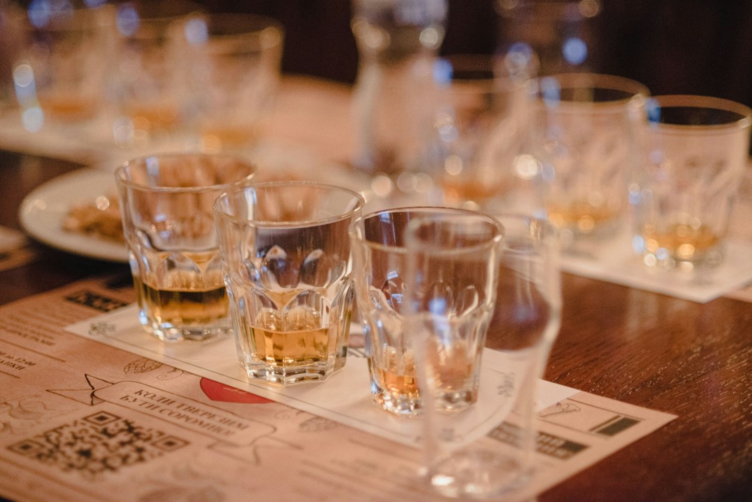 Mehrere Whisky-Verkostungsgläser auf einem Holztisch